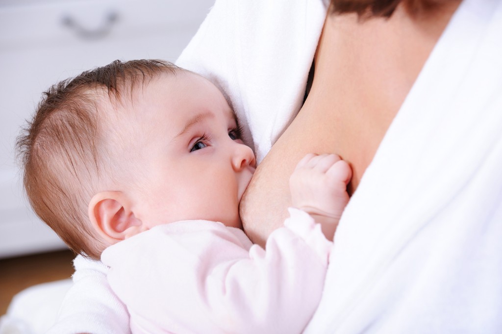 Close-up portrait of breastfeeding for little newborn baby - indoors