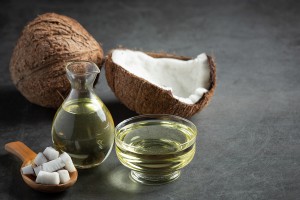 a jug of coconut oil whit coconut put on dark background